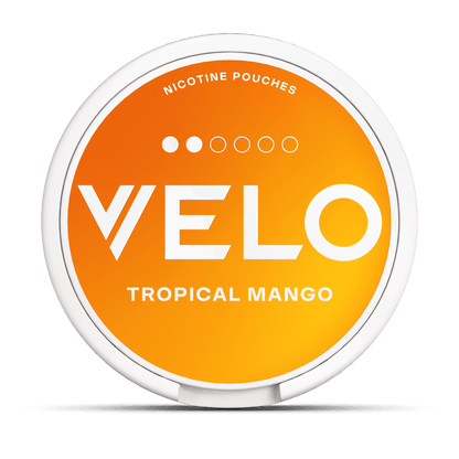 Round container labeled "VELO Tropical Mango," with an orange gradient design. The lid reads "NICOTINE POUCHES" and displays small circles, set against a plain background.